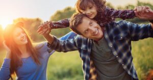 mother and father with daughter on father's shoulders