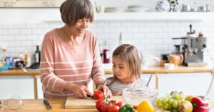 grandmother with her granddaughter cooking in the kitchen